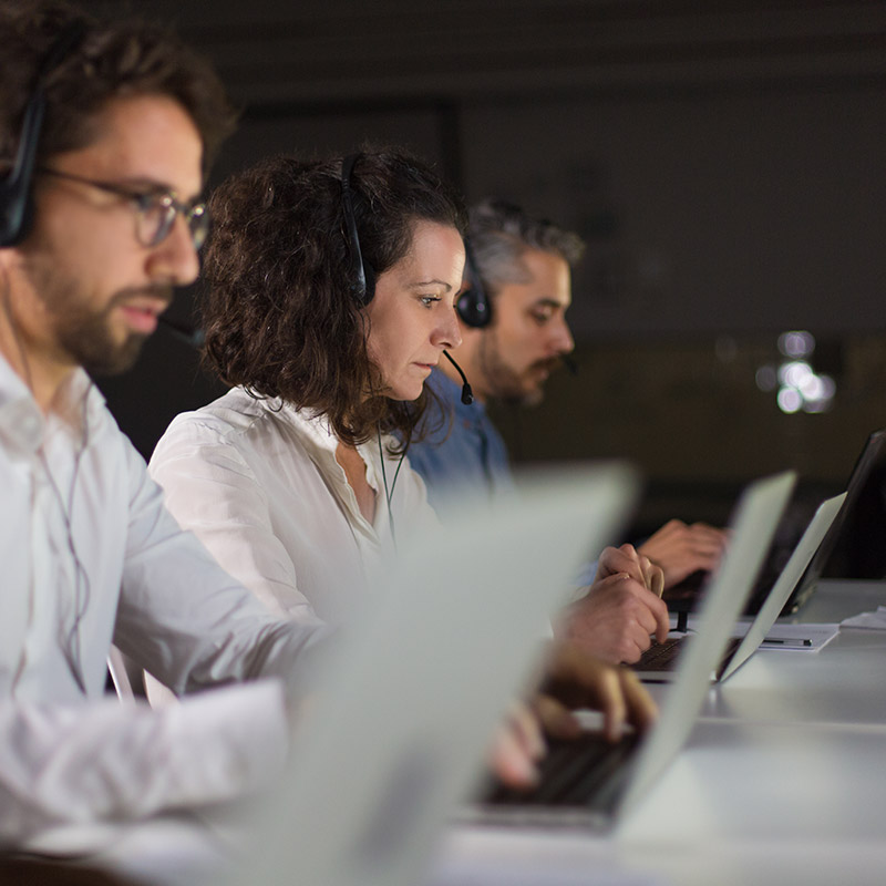 An image of people working at laptops with headsets on | IT Helpdesk in Falkirk, IT Emergency Support in Falkirk, IT Support for Small Businesses in Falkirk