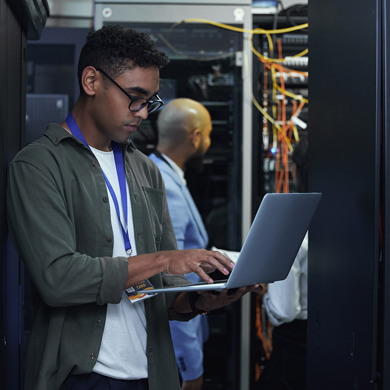 An image of a man holding a laptop in a data centre | IT Maintenance in Falkirk