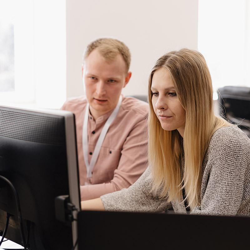 Two people working together at a desktop in an office | Microsoft IT Support in Falkirk, IT Support for Small Businesses in Falkirk