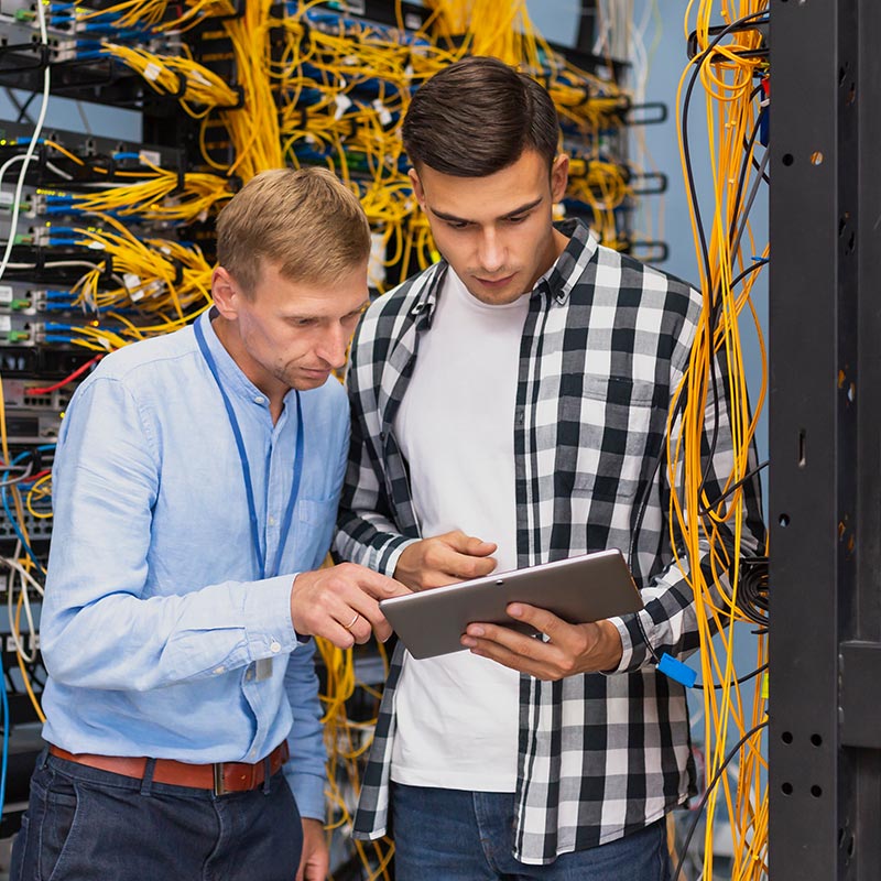 Two people looking at a tablet in a server room | Network Support in Falkirk