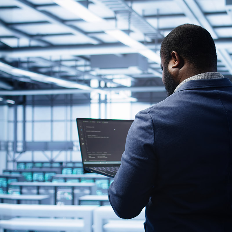 Am image of a person holding a laptop in a server room | Remote IT Support in Falkirk